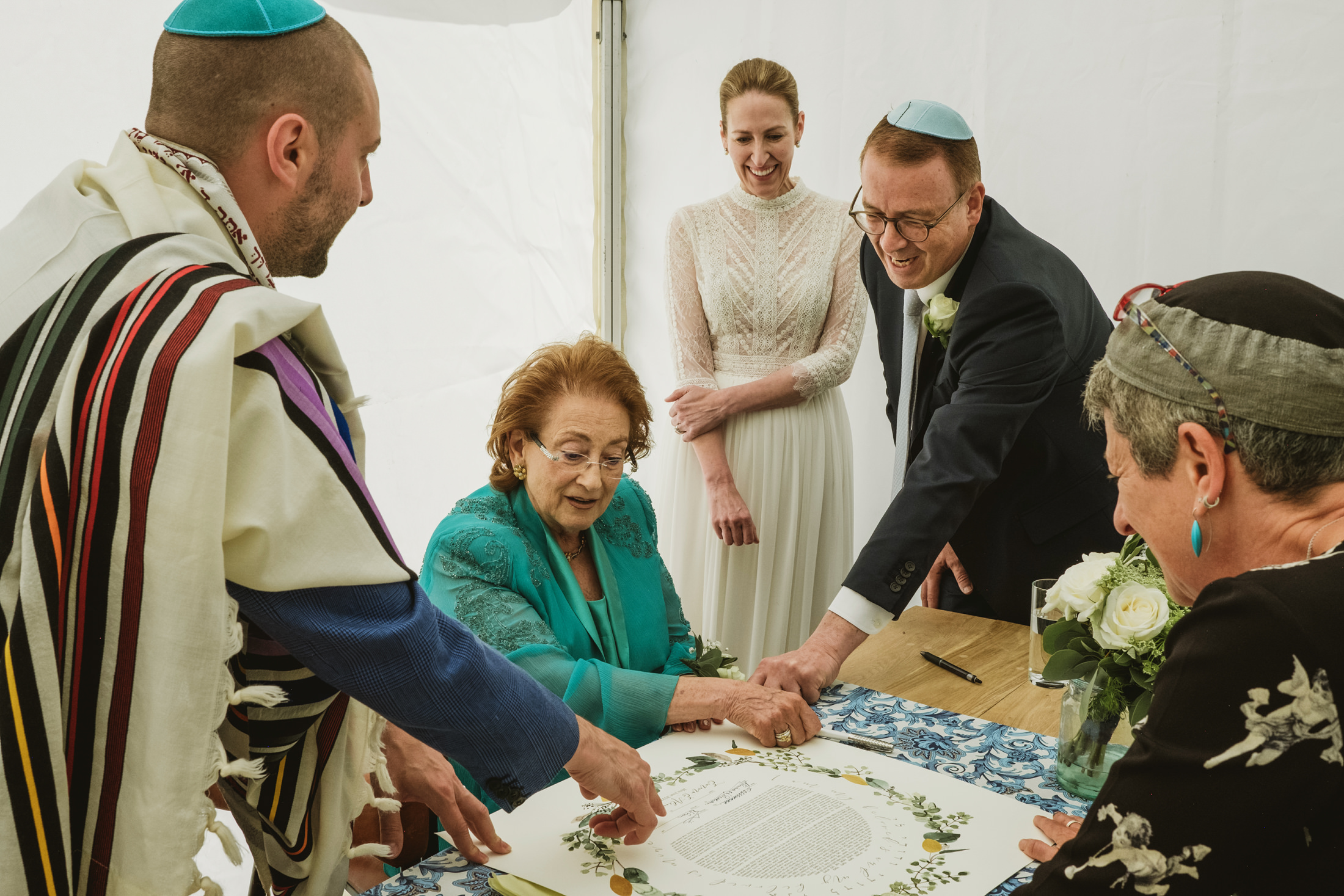 People signing a wedding ketubah document.