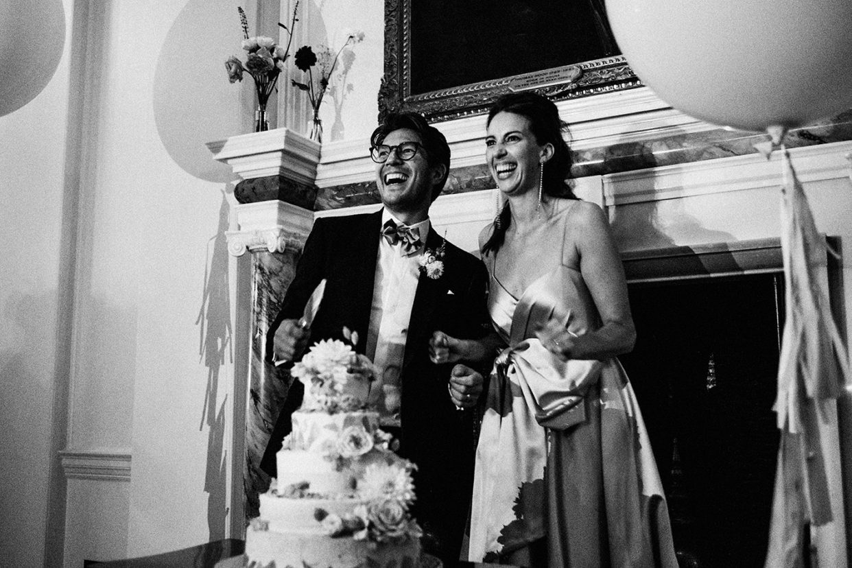 The Ned Wedding Photography London cutting of cake. Black and white wedding photo.