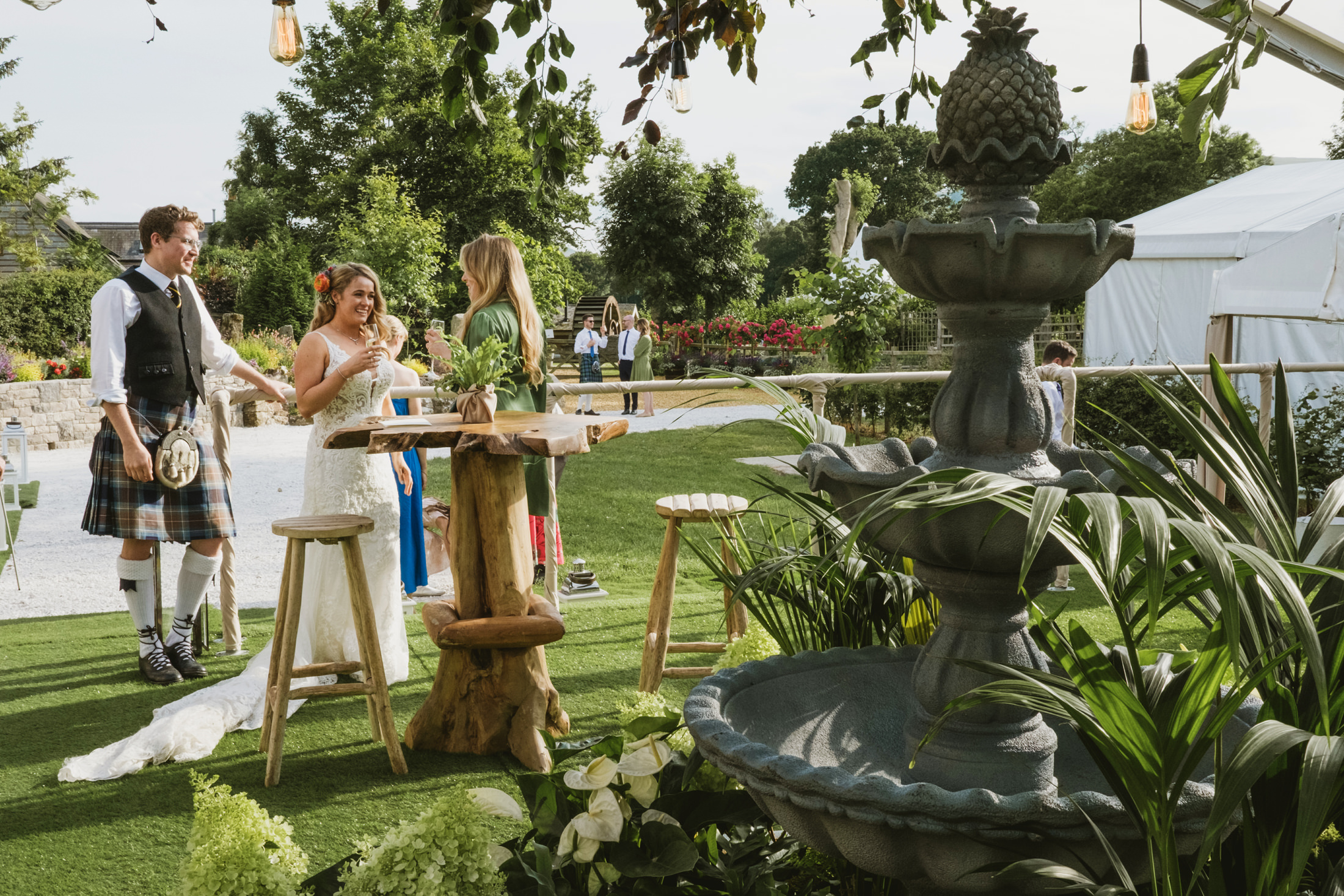 Outdoor wedding reception with fountain and guests