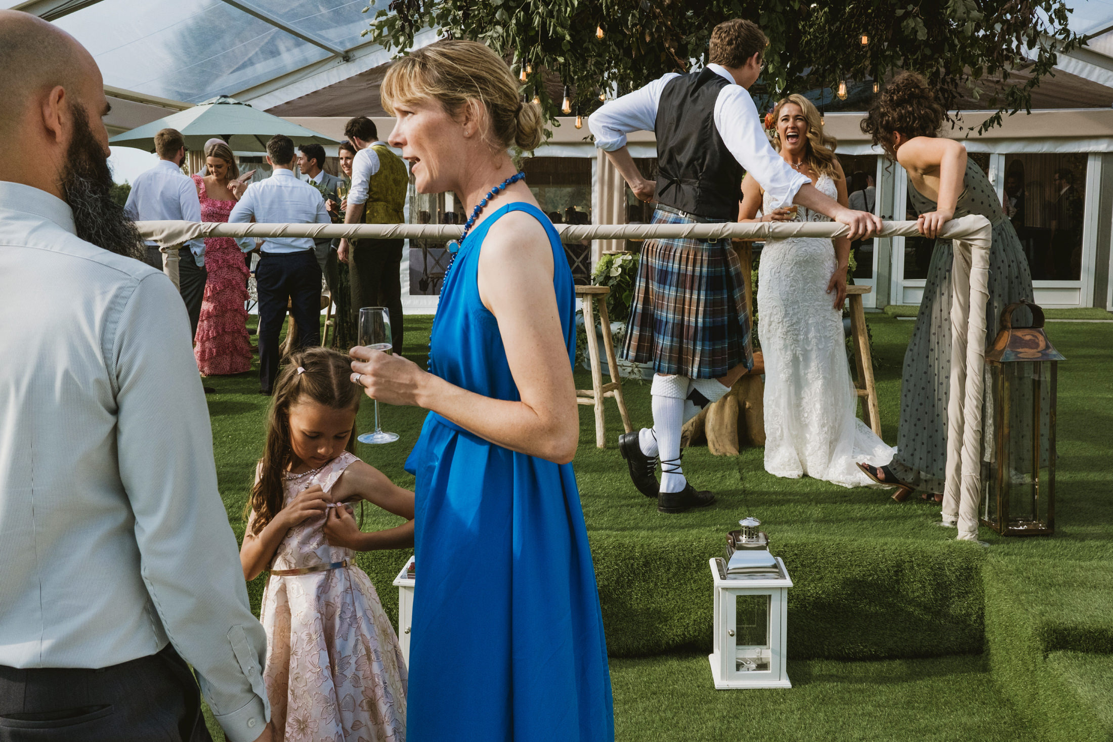 Guests socialising at outdoor wedding reception.