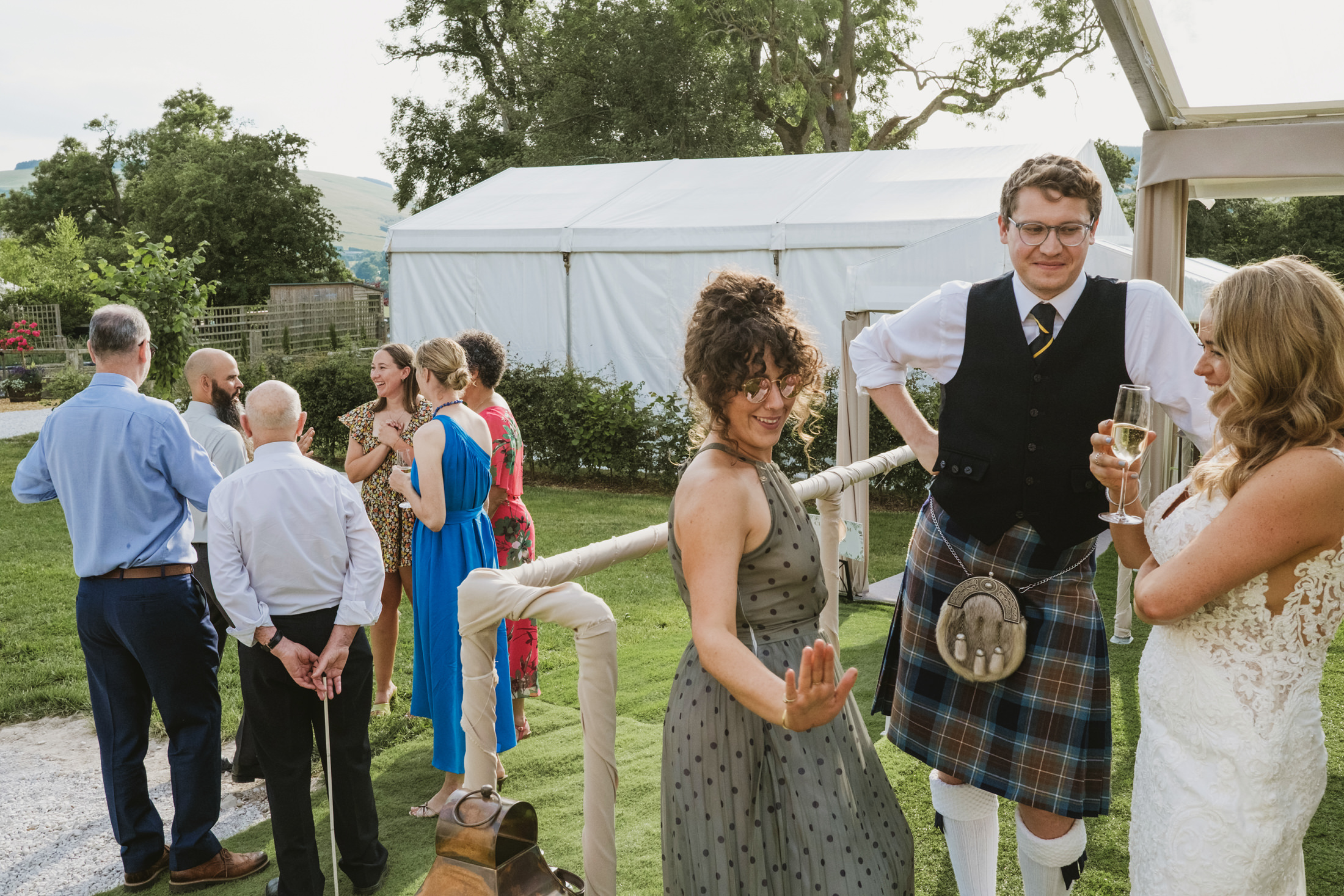 Wedding guests celebrating outdoors in a garden setting.