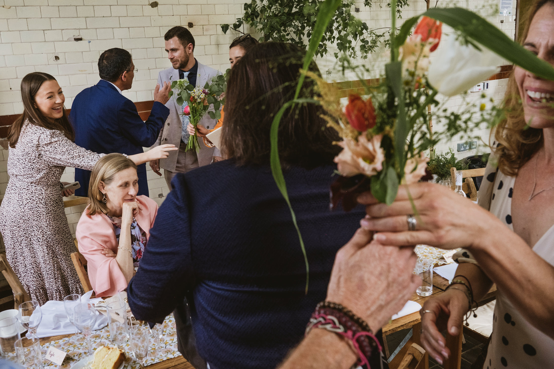 People gathering with flowers at a celebration.