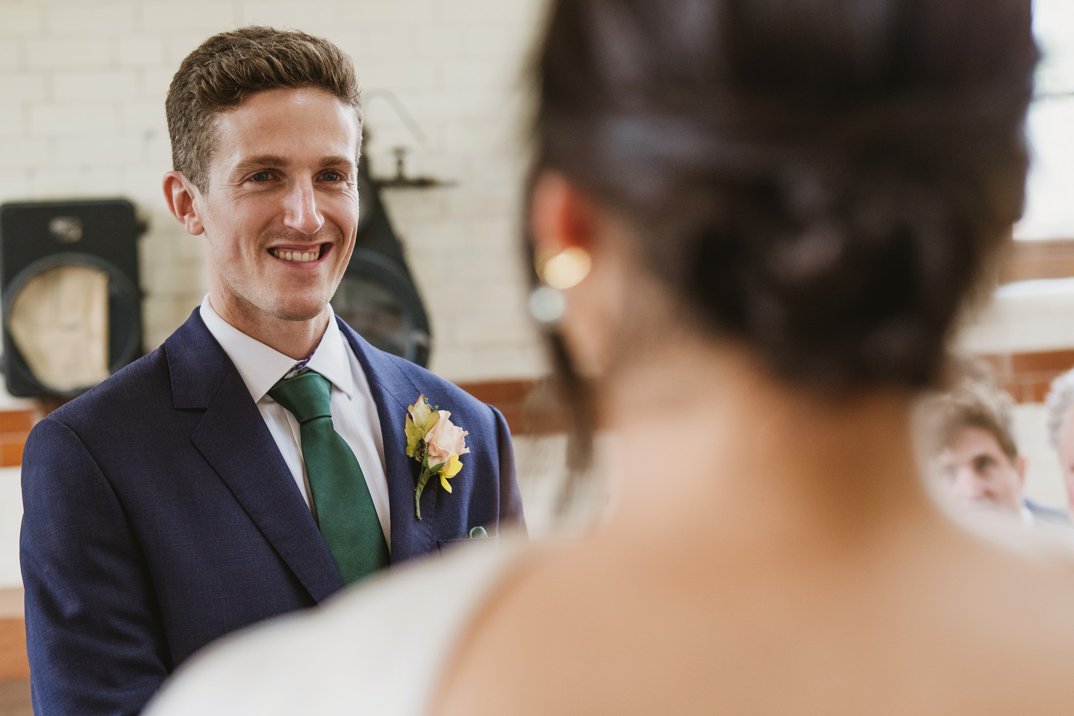 Smiling groom during wedding ceremony indoors.