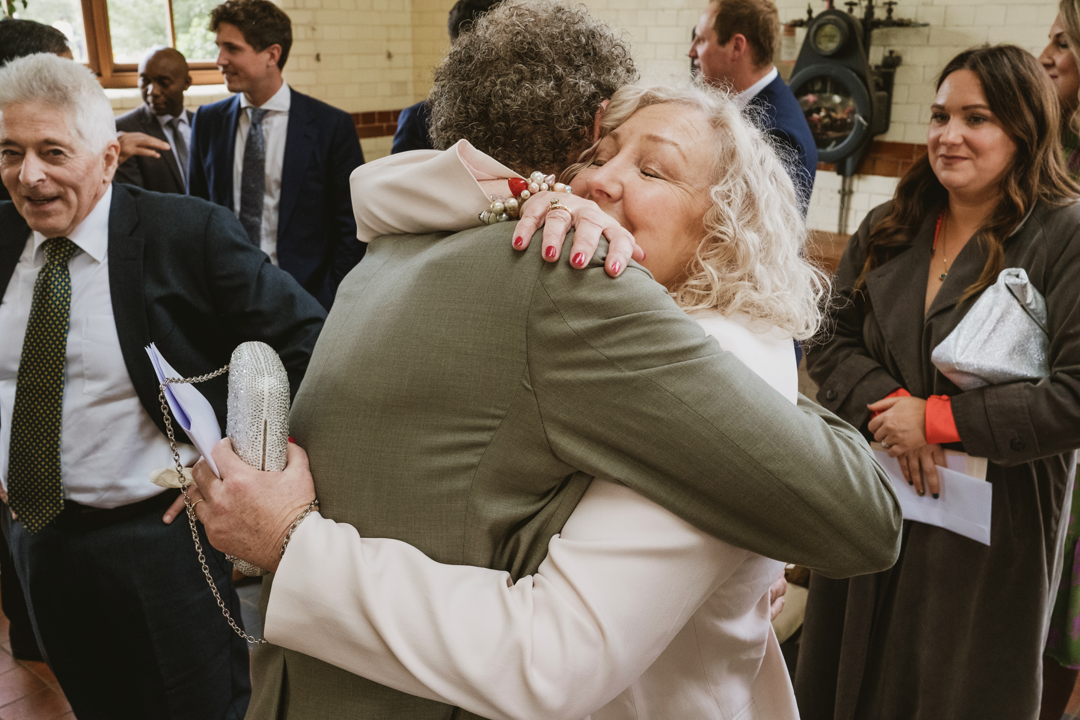 People embracing at a social gathering indoors.