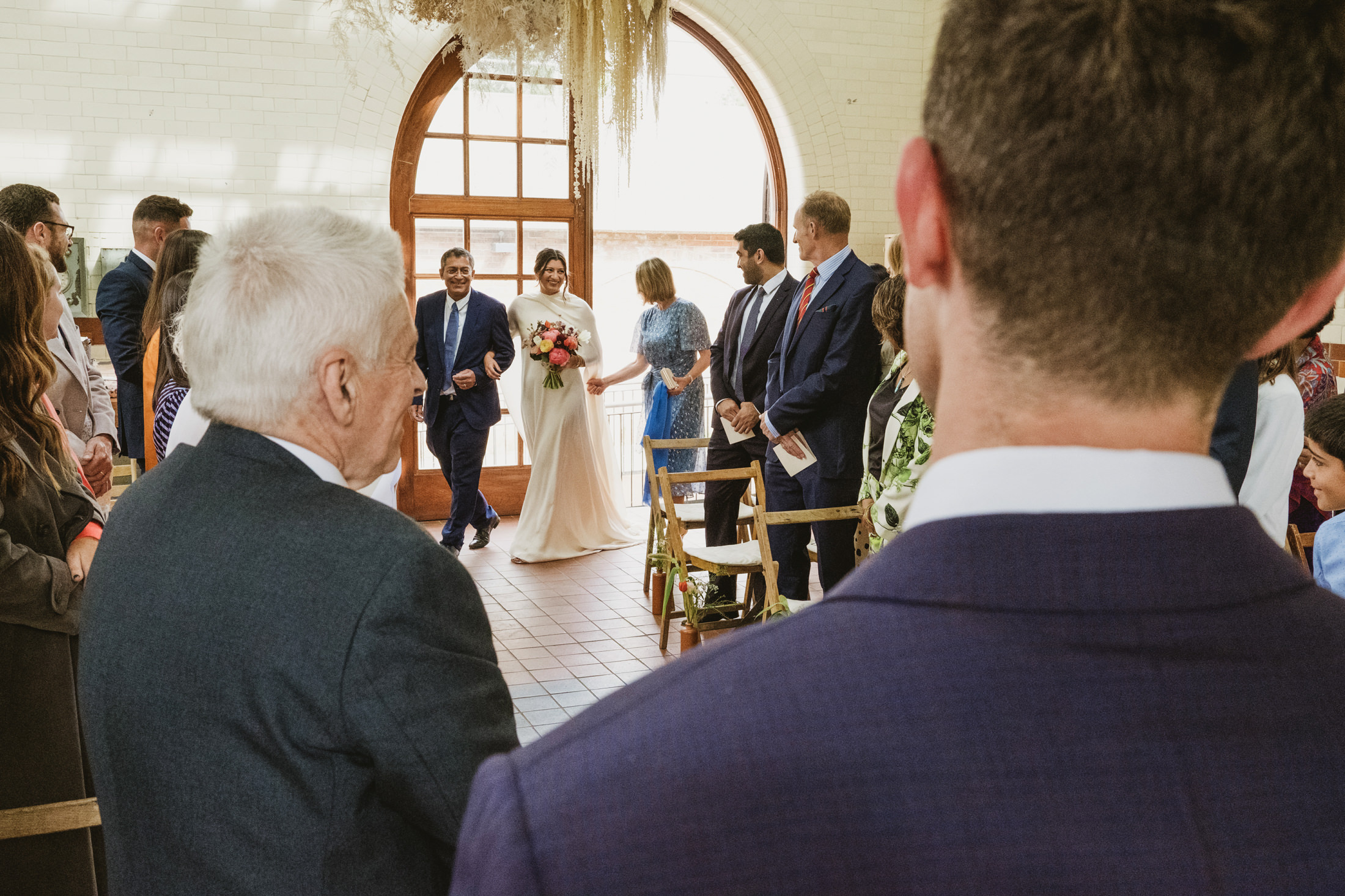 Bride walking down aisle at wedding ceremony.