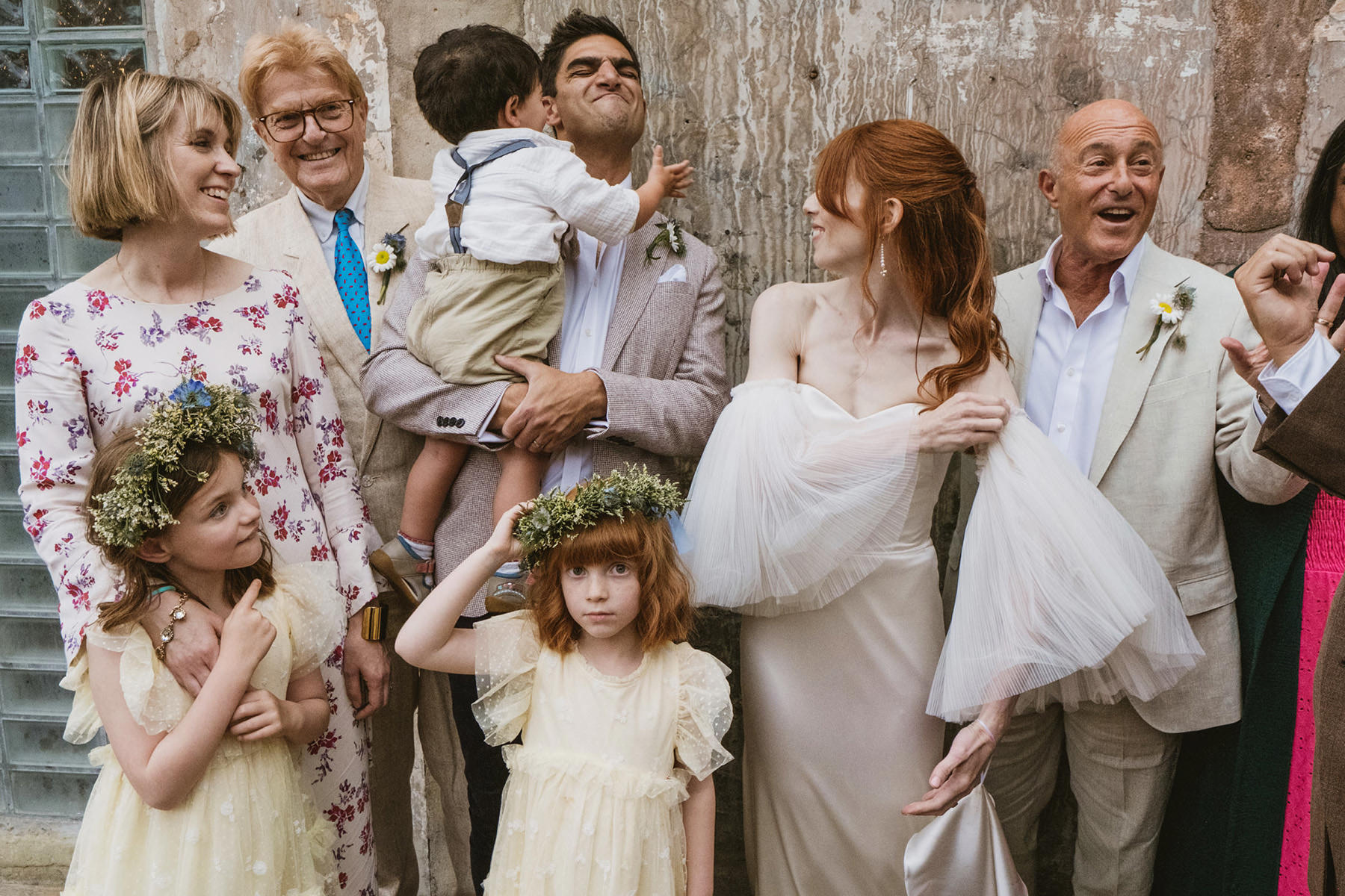 A spontaneous documentary photograph of a bride sharing a laugh with her family in the industrial interiors of Clapton Country Club.