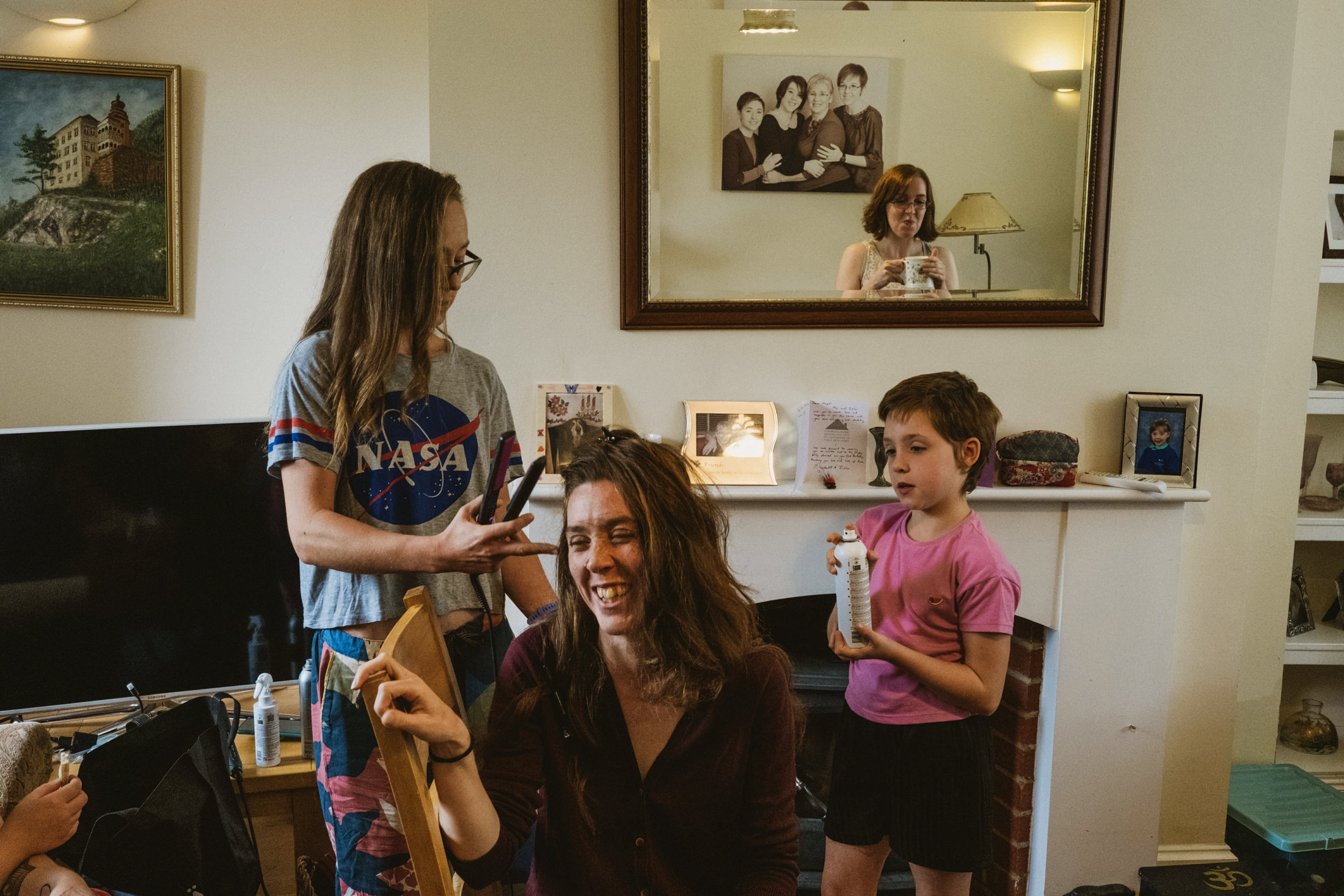 Family haircut session with mirror reflection.