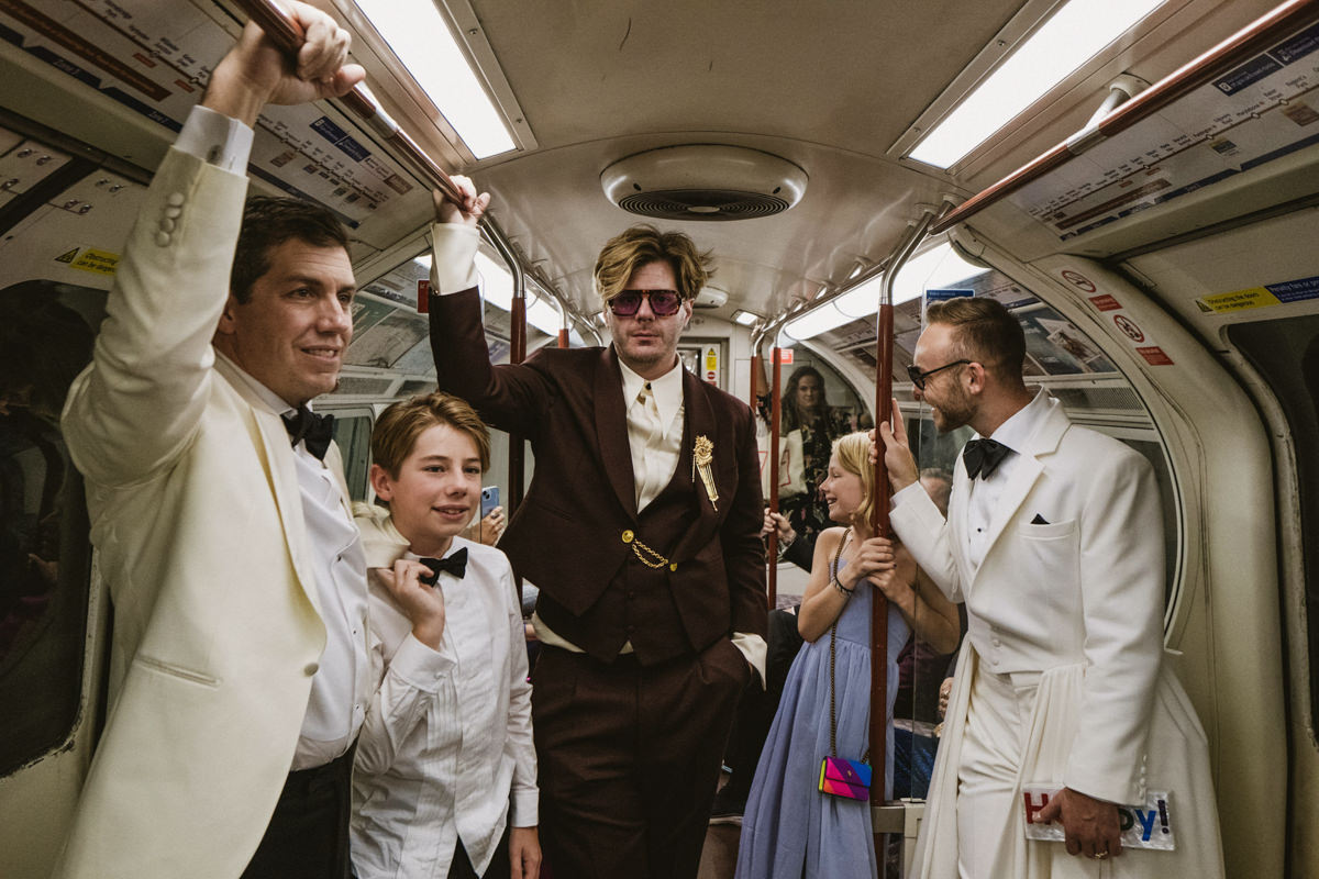 Group in formal wear on the London Underground at a wedding
