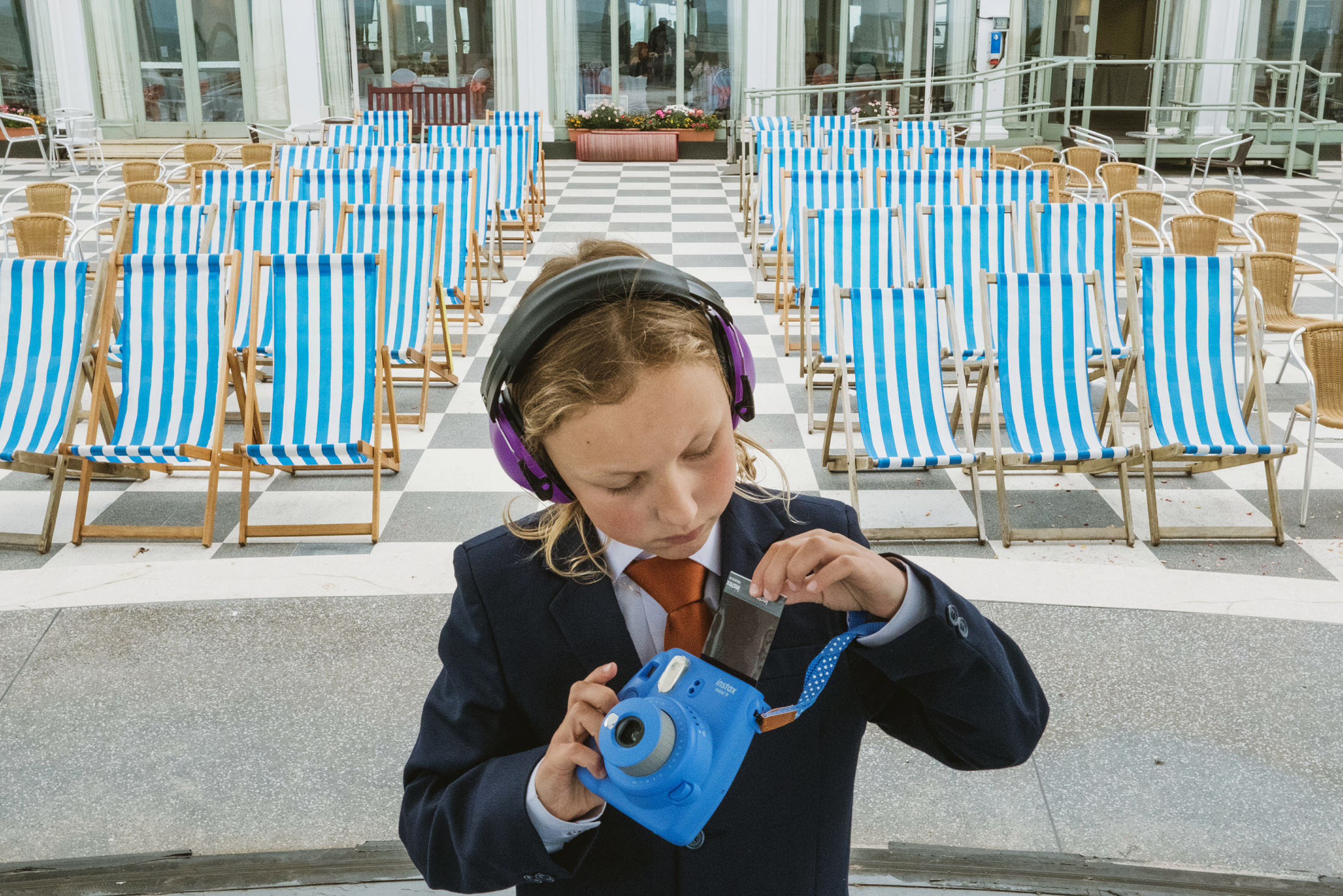 Child in suit with camera and headphones