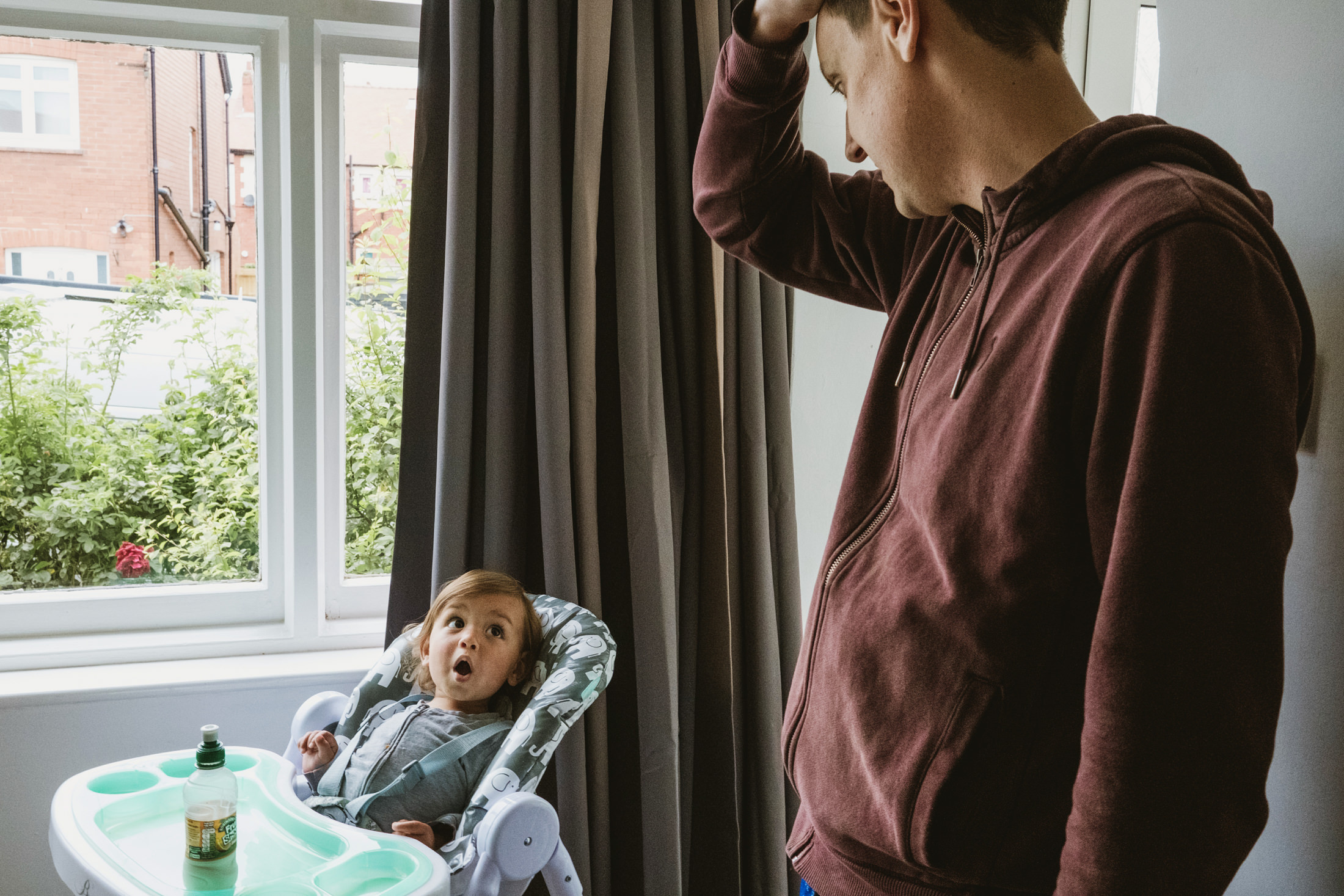 Man and surprised child in high chair
