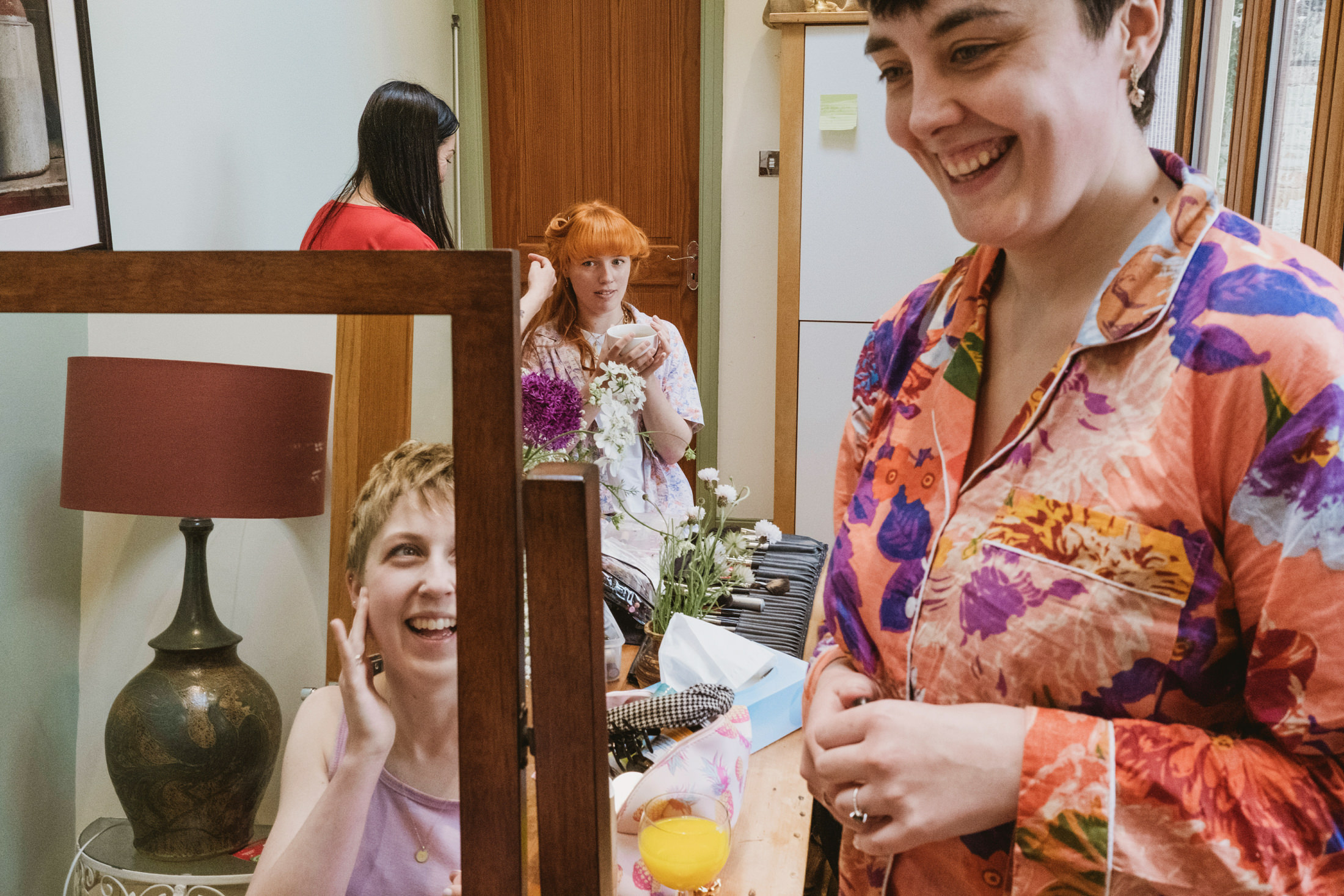 Women getting ready with makeup and flowers.