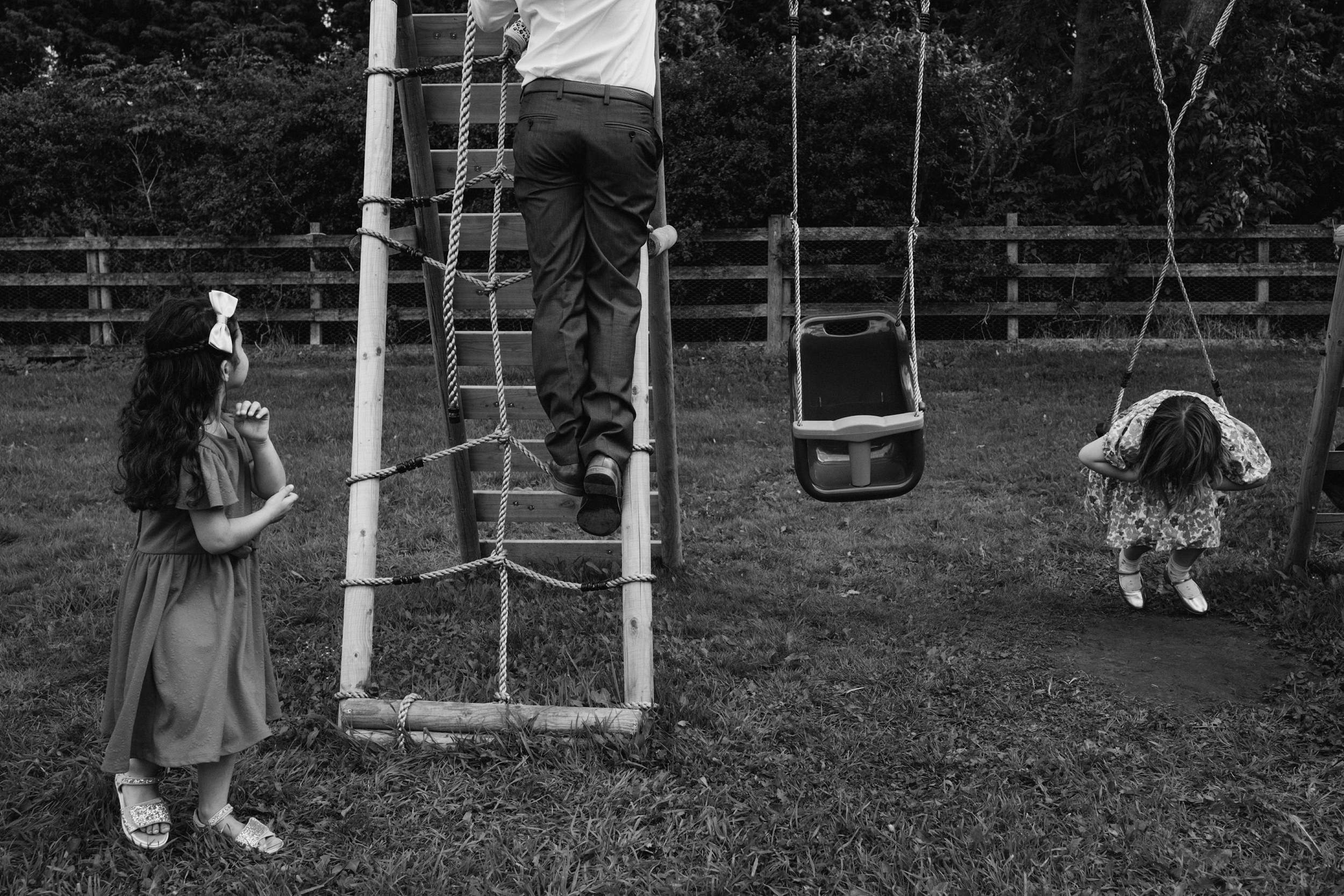Children playing, man climbing wooden ladder
